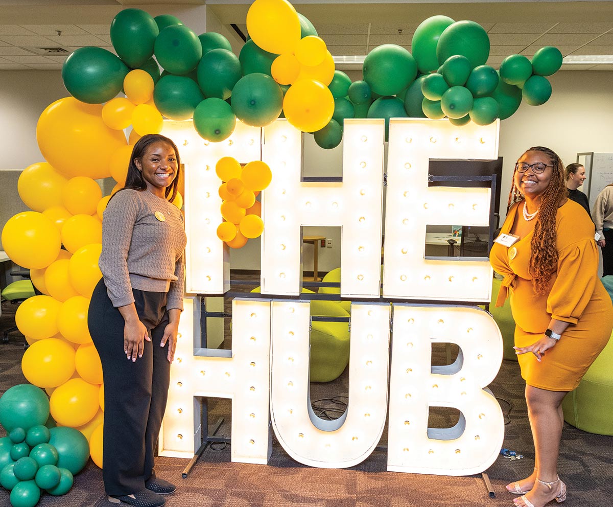 Two women with large "THE HUB" sign