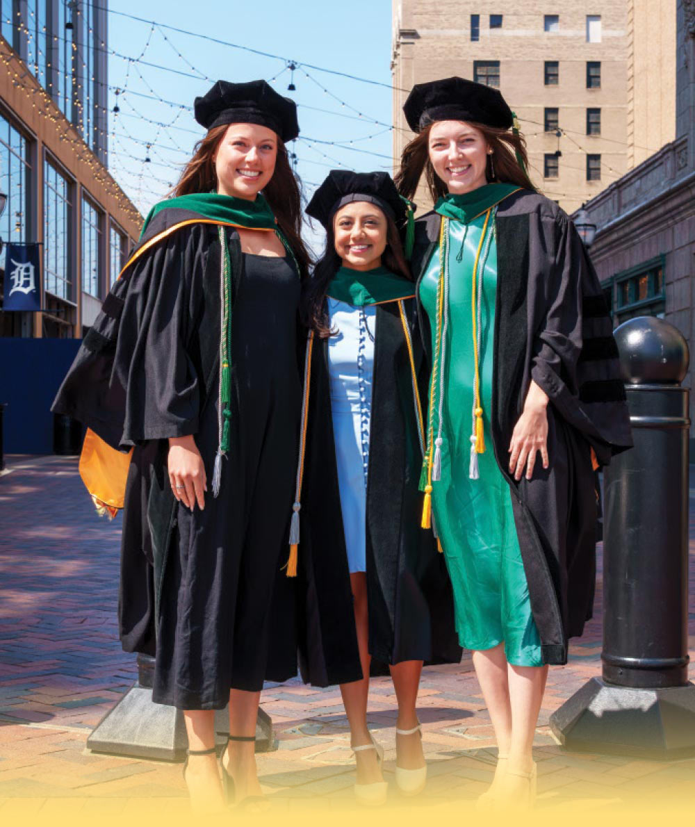Three women in black graduation gowns