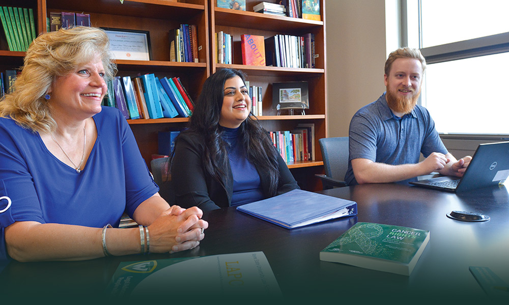 Three people at a conference table